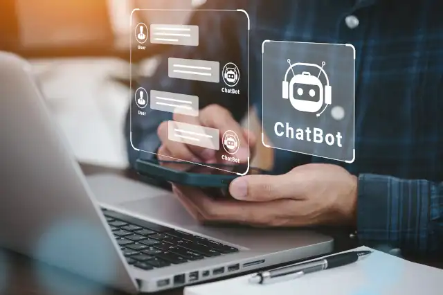AI ChatBot concept on a laptop and hand